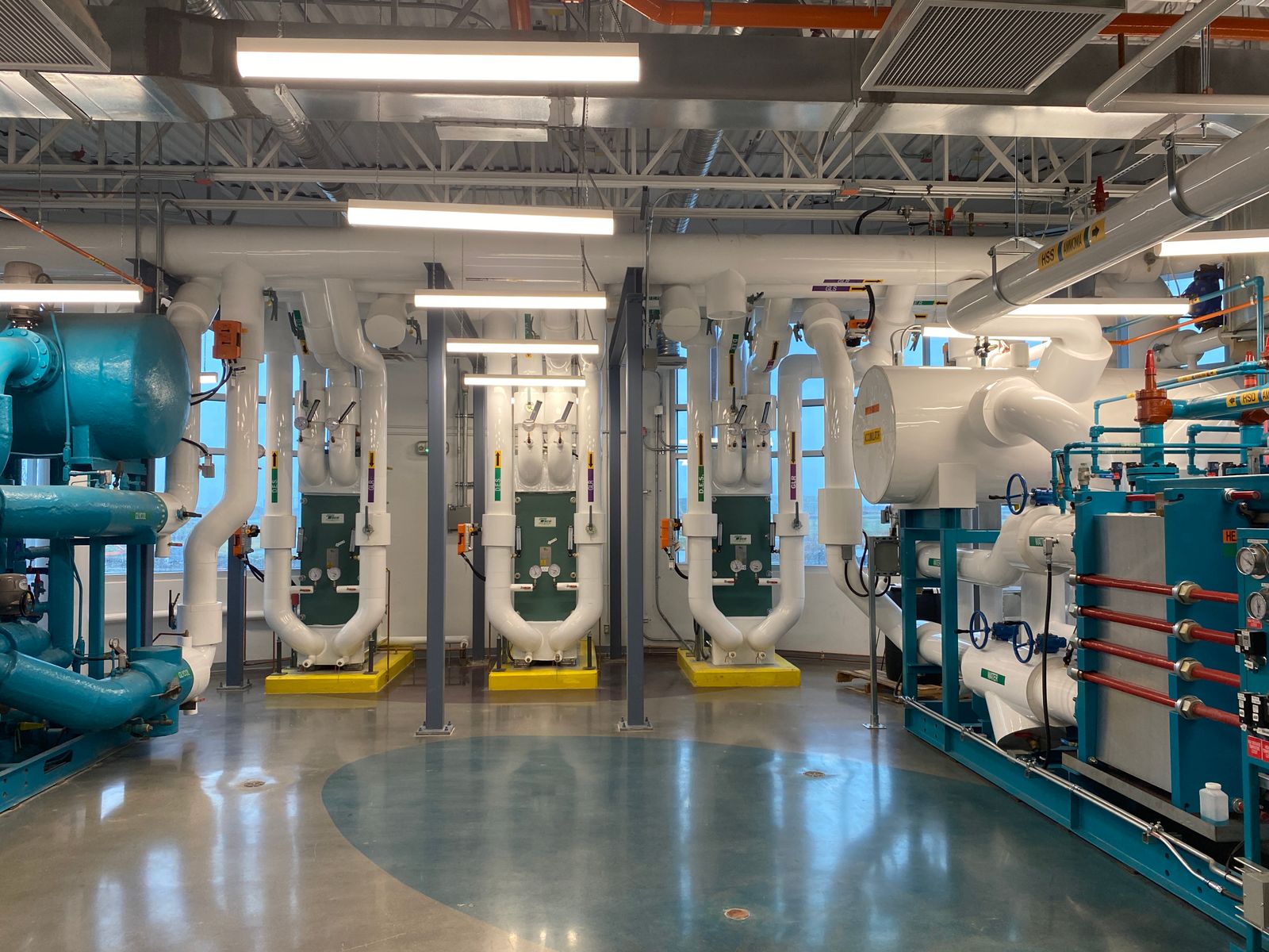 Technikzentrale eines Gebäudes mit Pumpen, Wärmetauschern und Verteilern