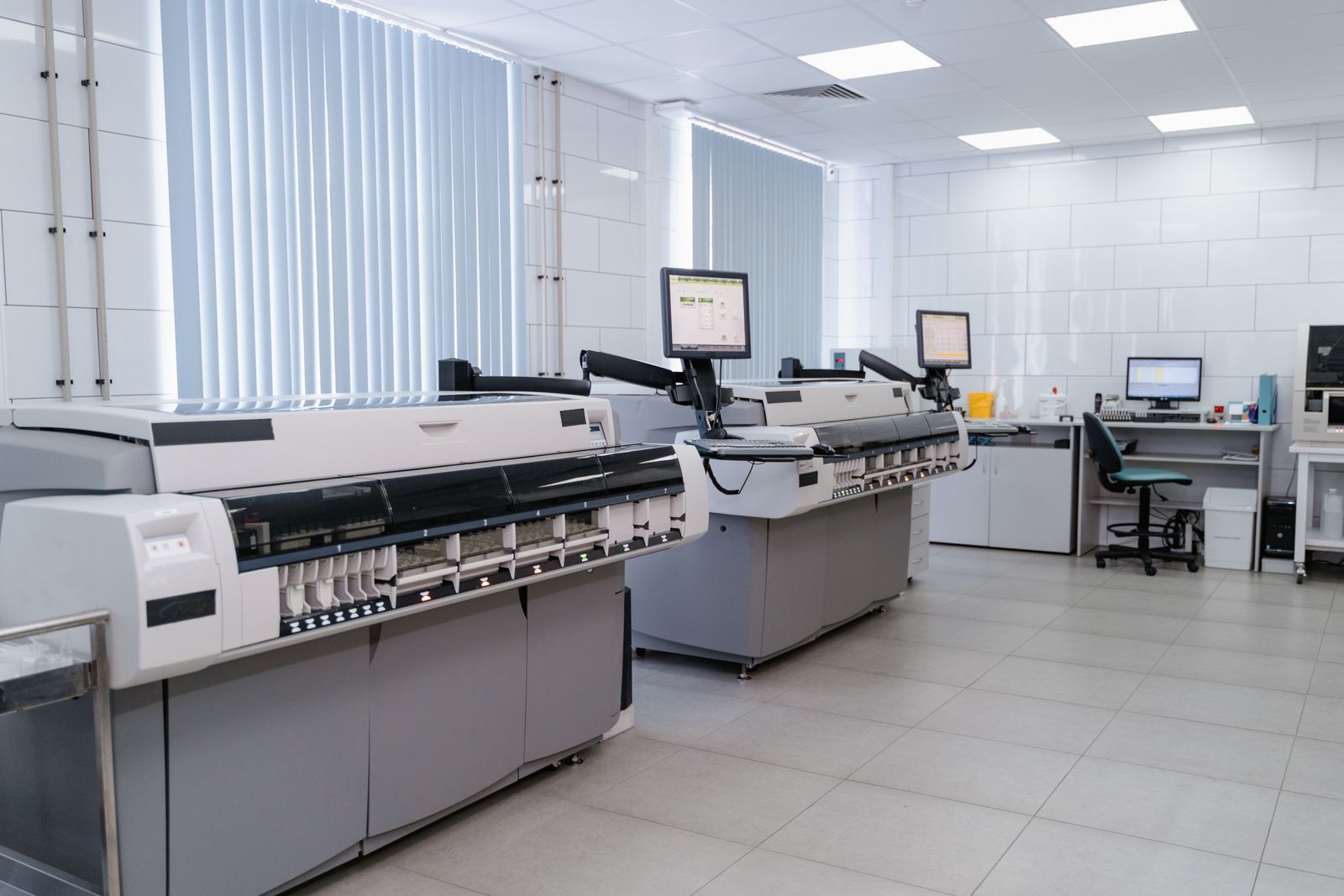 Laborraum mit Analysestraße, Bedienmonitoren und PC-Arbeitsplatz